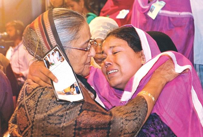 Prime Minister Sheikh Hasina consoles Layla Khatun, widow of police constable Hazrat Ali, who was killed while guarding a police post in Gaibandha during a spate of BNP-Jamaat violence last year. They met at the publication ceremony of a photo album Roktakto Bangladesh (Bloodstained Bangladesh) in the capital's Osmani Memorial Auditorium, containing photos of the barbaric activities, which left many civilians dead too. Photo: BSS