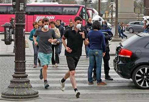 In this March 17 file photo, two joggers wearing protective masks run past a police officer controlling a vehicle on the Concorde square in Paris. Air pollution kills about 7 million people worldwide every year according to a new report from the World Health Organisation published Tuesday March 25. Photo: AP