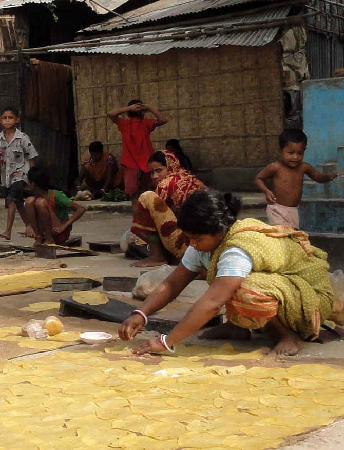 A woman with her family members busy making poppadoms at Jogenbabur Math in Dinajpur town.  PHOTO: STAR