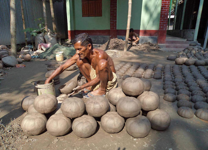 A potter makes earthenware at Kumarpara in Kurigram town. PHOTO: STAR