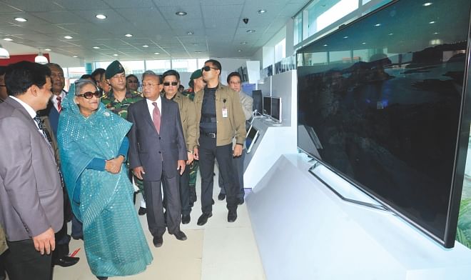 Prime Minister Sheikh Hasina looks at some large-screen TVs at a stall after inaugurating the International Trade Fair in the capital yesterday. Photo: BSS