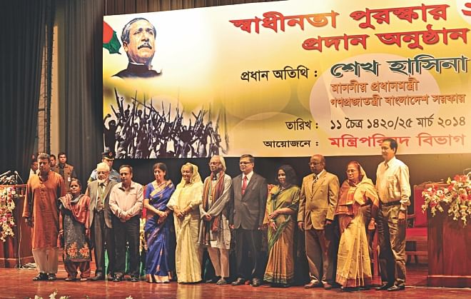 Prime Minister Sheikh Hasina with the recipients of Independence Award 2014 and their representatives in the capital's Osmani Memorial Auditorium yesterday. A total of nine eminent persons and a government organisation got the award this year.  Photo: BSS