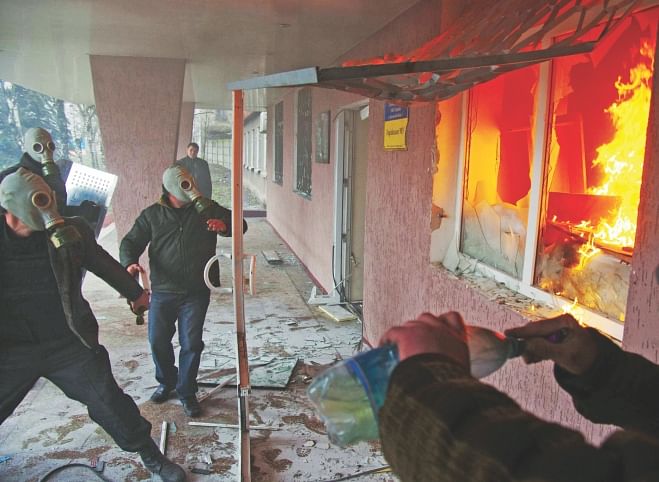 Pro-Russia protester storm a regional police building as one prepares a petrol bomb in the eastern Ukrainian city of Horlivka on Monday. Photo: AFP