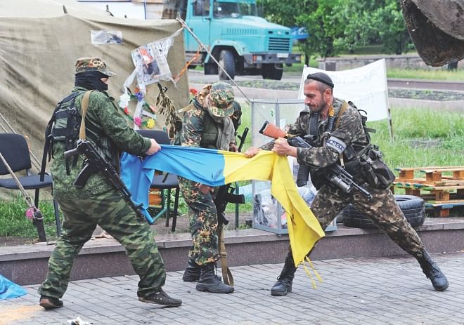 Pro-Russian fighters of Vostok (East) battalion rip apart an Ukrainian flag outside a regional state building in the eastern Ukrainian city of Donetsk on Thursday.  Photo: AFP