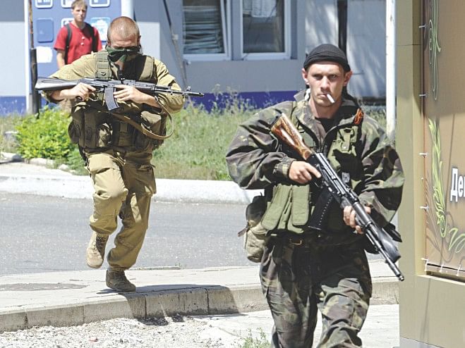 Armed pro-Russian separatists run during clashes between Ukrainian government troops and pro-Russian rebels that left at least three people dead in the eastern Ukrainian city of Donetsk yesterday. Photo: AFP