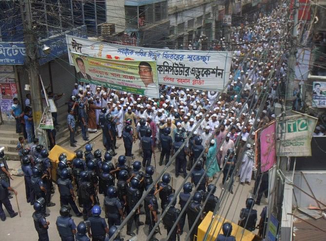 Police halt the procession of pro-Islamist Osamajik Karjokolap Protirodh Committee while going to besiege the Kandapara brothel in Tangail town yesterday. The processionists later held a sit-in blocking the busy road for hours. PHOTO: STAR
