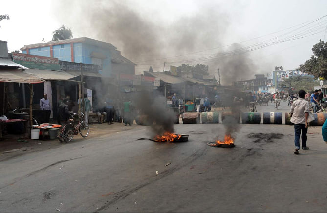 People of Phulbari put up a barricade and burn tyres on Dinajpur-Dhaka highway at Nimtola under Phulbari municipality yesterday, protesting the visit of Gary Lye, chief executive officer (CEO) of Asia Energy, on Wednesday. Photo: Star