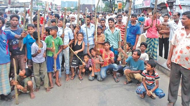 Several hundred workers of Sonali Jute Mills and Ajax Jute Mills and their children block Phulbaria level crossing in Khulna city yesterday, demanding Eid bonus, arrears, and also reopening of the privately owned factories. The two mills at the city's Mirerdanga have been closed for one year, but protesters said the authorities had recently assured them of reopening. The demonstration disrupted rail and road communications in the area for four hours till 12:00 noon, causing immense suffering to commuters.   Photo: Banglar Chokh