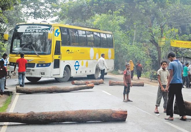 People block Dhaka-Pabna highway at Dharmagram with logs yesterday protesting the attack and killing of Awami League men in Pabna.  Photo: Star