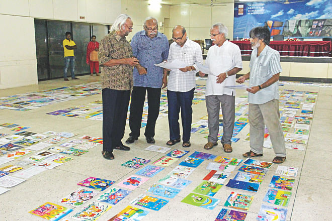 From left, artists Qayyum Chowdhury, Rafiqun Nabi, Samarjit Roy Chowdhury, Abul Barak Alvi, and Ashok Karmaker, judges of an Eid card designing contest of the Prothom Alo and Square Toiletries Ltd, looks at designs sent by children under the age of 15 during an exhibition of the designs in the auditorium of CA Bhaban in the capital yesterday. Photo: Star