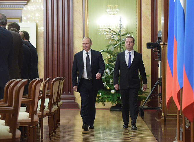Russian President Vladimir Putin (L) and Prime Minister Dmitry Medvedev attend a meeting with members of the government in Moscow, December 25, 2014. Photo: Reuters