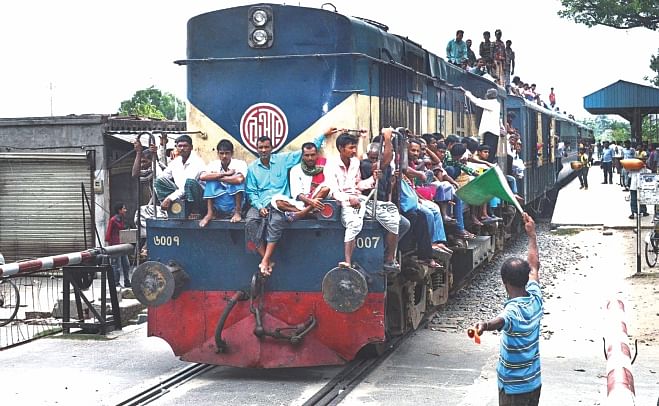 Failing to find room inside, people travel on the roof and the locomotive of a train at Court Railway Station in Rajshahi as there is no other option for them. Transport workers of the division have been on strike since Sunday.  Photo: Star