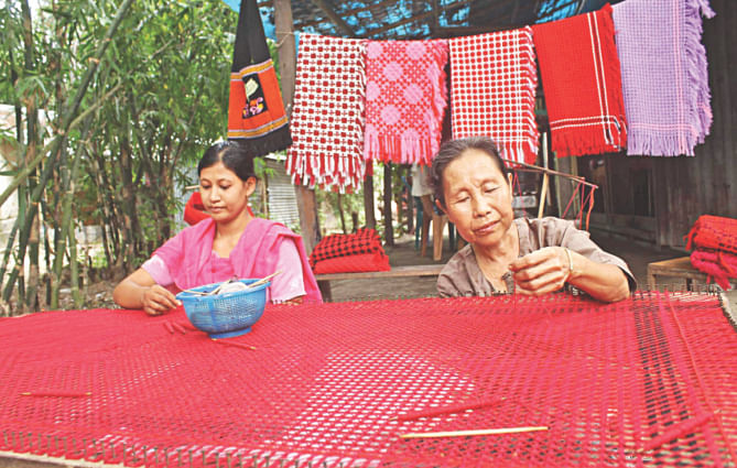 Rakhain women weave artistic shawl with handloom at their Mistripara house in Kuakata of Kalapara upazila under Patuakhali district yesterday. Traditional warm clothes made by the indigenous community are in good demand, especially to the tourists coming to the seas beach area in winter.  PHOTO: STAR