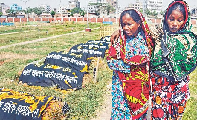 Two grieving family members of victims of Rana Plaza collapse pay respects at the graves of those who died when the nine-storey building pancaked on April 24 last year killing at least 1,138 people and injuring several hundred. The picture was taken yesterday at the capital's Jurain graveyard. Photo: Star
