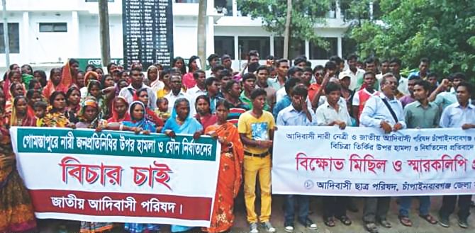 Indigenous people brought out a procession in Chapainawabganj town yesterday, demanding immediate arrest of those who beat up and raped an indigenous woman leader in Gomostapur upazila of the district on Monday. PHOTO: STAR