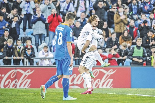 Real Madrid midfielder Luka Modric (C) celebrates his goal with teammate Alvaro Arbeloa (R) during their Primera Liga encounter against Getafe at the Alfonso Perez Stadium on Sunday. Photo: AFP