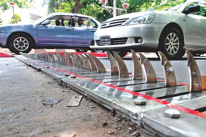 The retractable spike strip installed on Hare Road in Dhaka yesterday to prevent motorists from driving on the wrong side of the road.  Photo: Anisur Rahman
