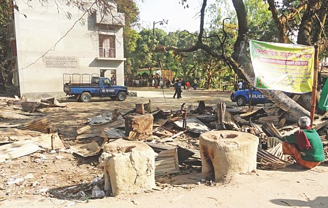 A banner hangs calling for an end to communal violence near Kornai Govt Primary School in Dinajpur amid the rubble of shops that had been levelled. The photo was taken at the end of January, weeks after the violence broke out centring the January-5 elections. Photo: Star