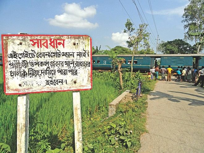 The road was built by the government, the rail tracks too. But for any accident at this unprotected level crossing, it is the pedestrians or drivers who will be held responsible. Conveying a warning is all that the authorities have done. This level crossing, on Jail Road in Lalmonirhat town, has neither a gate nor a guard. Photo: Star