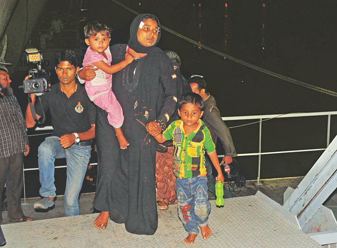 A woman with her two children gets off a Bangladesh Navy vessel at Patenga in Chittagong last night. She is one of the Malaysia-bound fortune seekers rescued in the Bay. Photo: Star