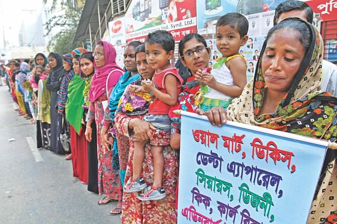 Garment workers form a human chain in front of the National Press Club in Dhaka yesterday to demand arrest of the owner of Tazreen Fashions where a fire killed 112 people last year. The workers also sought compensation from western retailers who sourced garments from Tazreen. Photo: star
