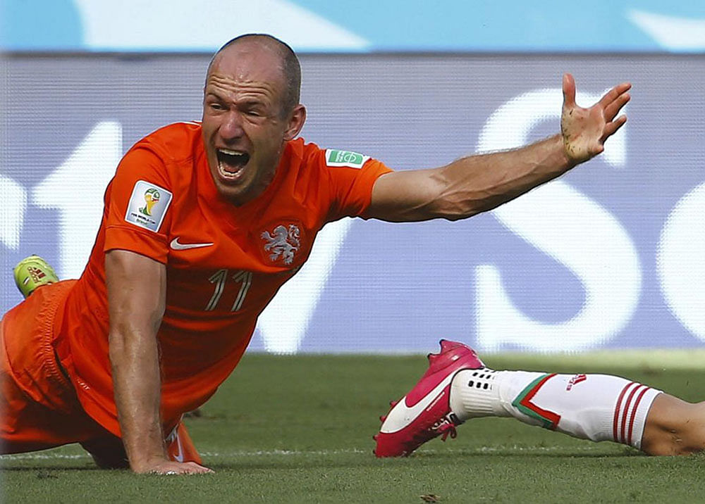 Arjen Robben of the Netherlands reacts after being tackled by Mexico's Miguel Layun during their 2014 World Cup round of 16 game at the Castelao arena in Fortaleza June 29, 2014.