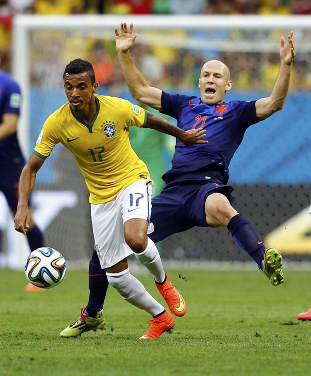 Brazil's Luiz Gustavo (L) and Arjen Robben of the Netherlands fight for the ball during their 2014 World Cup third-place playoff at the Brasilia national stadium in Brasilia July 12, 2014.