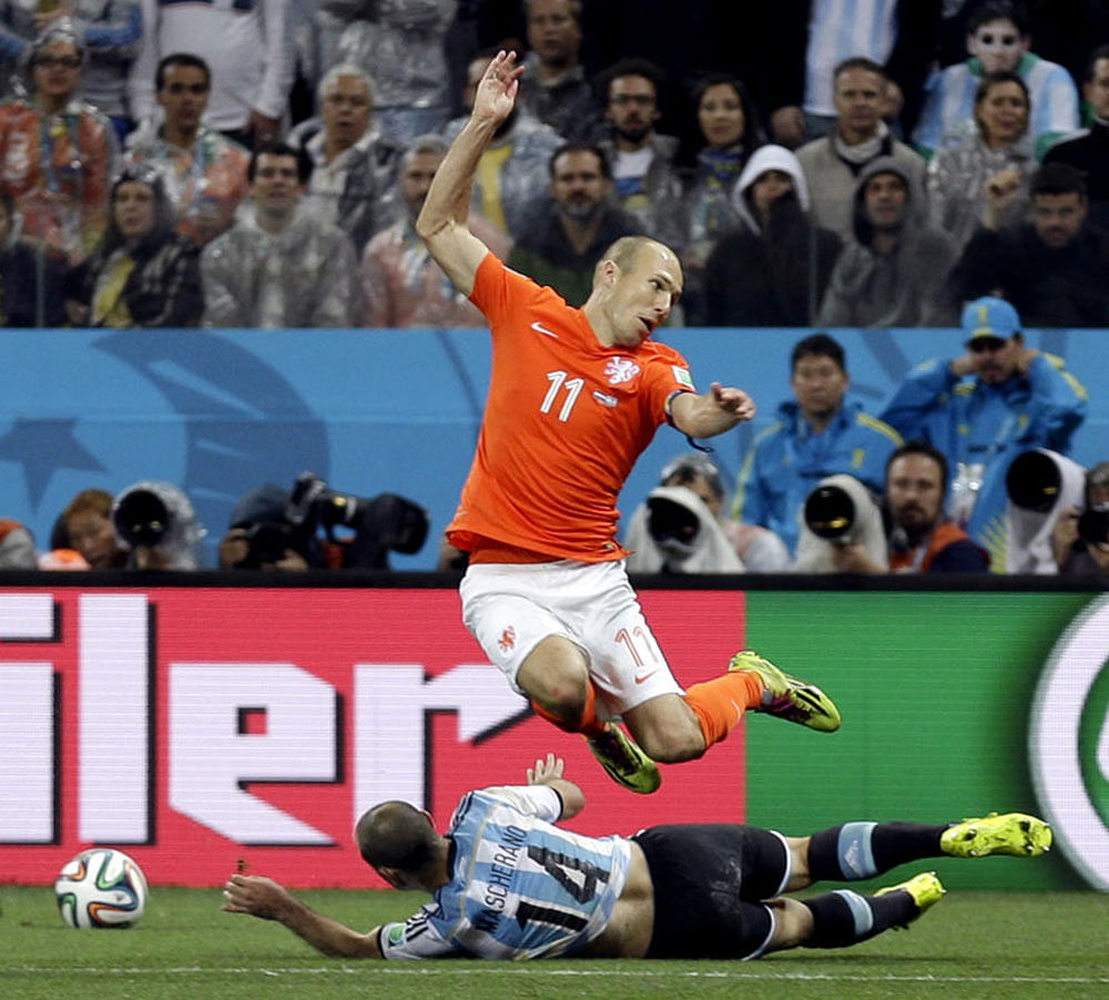 Netherlands' Arjen Robben (11) leaps over Argentina's Javier Mascherano (14) during the World Cup semifinal soccer match between the Netherlands and Argentina at the Itaquerao Stadium in Sao Paulo Brazil, Wednesday, July 9, 2014.