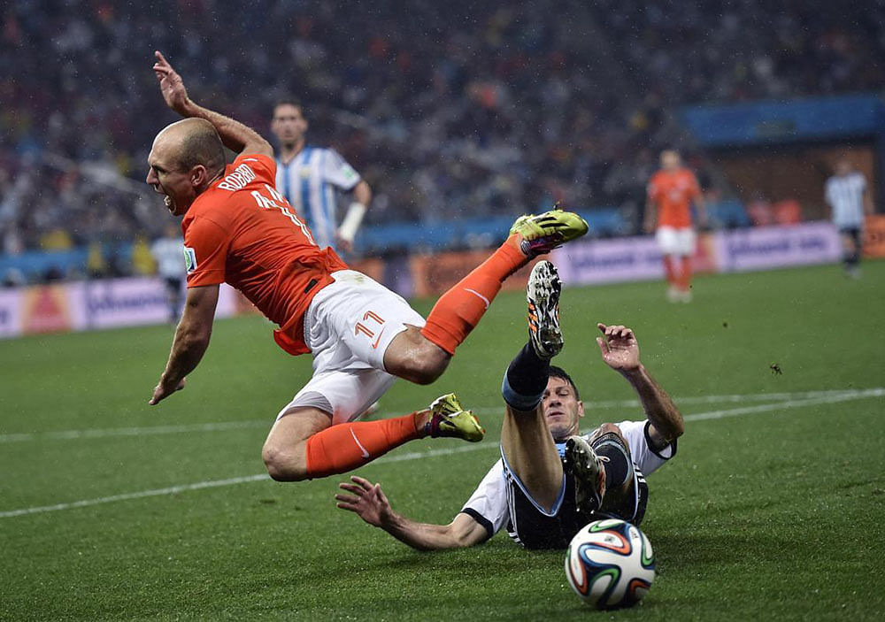 Netherlands' Arjen Robben goes down under a challenge from Argentina's Martin Demichelis during the World Cup semifinal soccer match between the Netherlands and Argentina at the Itaquerao Stadium in Sao Paulo Brazil, Wednesday, July 9, 2014.