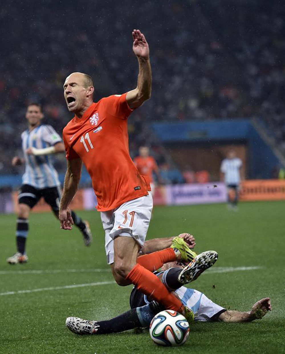 Netherlands' Arjen Robben goes down under a challenge from Argentina's Martin Demichelis during the World Cup semifinal soccer match between the Netherlands and Argentina at the Itaquerao Stadium in Sao Paulo Brazil, Wednesday, July 9, 2014.