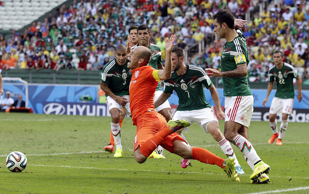 Netherlands' Arjen Robben, center, goes down to win a penalty during the World Cup round of 16 soccer match between the Netherlands and Mexico at the Arena Castelao in Fortaleza, Brazil, Sunday, June 29, 2014. Netherlands won the match 2-1.