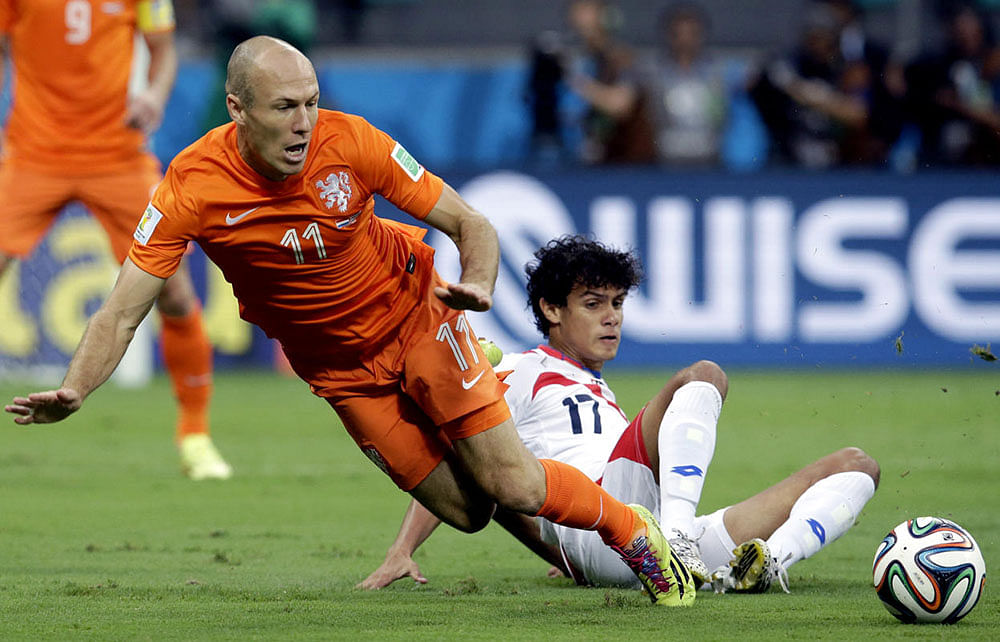 Netherlands' Arjen Robben (11) is tackled by Costa Rica's Yeltsin Tejeda (17) during the World Cup quarterfinal soccer match between the Netherlands and Costa Rica at the Arena Fonte Nova in Salvador, Brazil, Saturday, July 5, 2014.