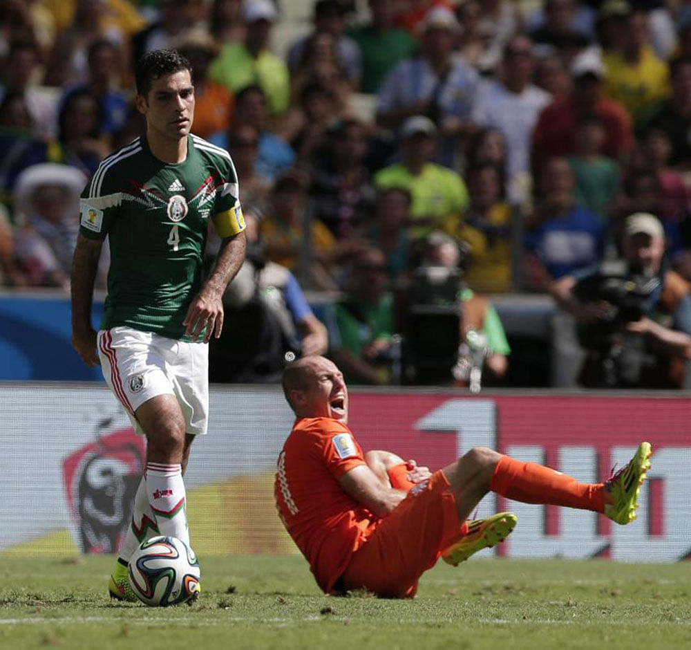 Mexico's Rafael Marquez controls the ball as Netherlands' Arjen Robben, right, grimaces during the World Cup round of 16 soccer match between the Netherlands and Mexico at the Arena Castelao in Fortaleza, Brazil, Sunday, June 29, 2014.