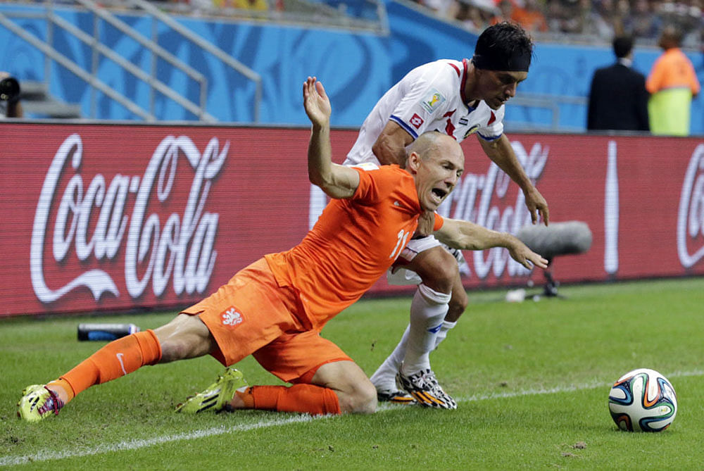 Netherlands' Arjen Robben falls while being held by Costa Rica's Christian Bolanos during the World Cup quarterfinal soccer match at the Arena Fonte Nova in Salvador, Brazil, Saturday, July 5, 2014.