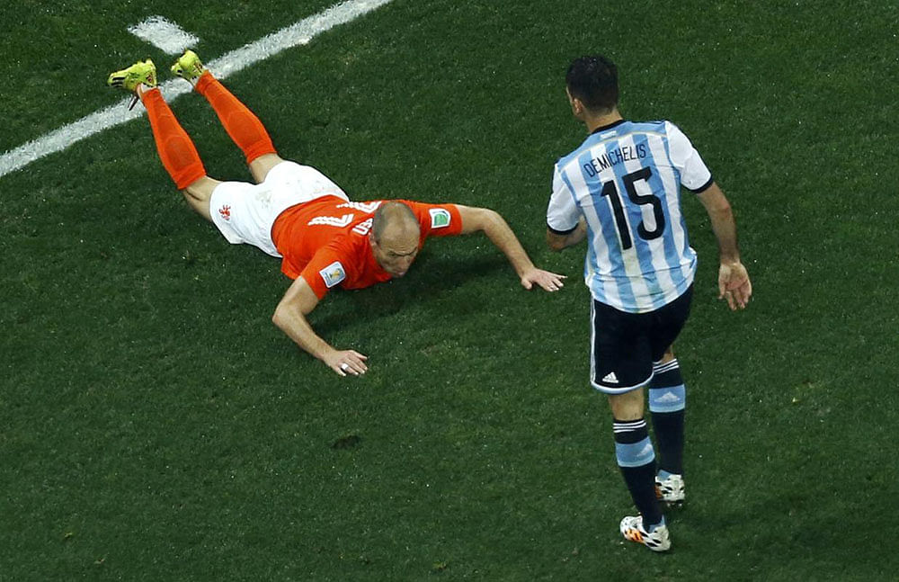 Arjen Robben of the Netherlands falls in front of Argentina's Martin Demichelis (R) during their 2014 World Cup semi-finals at the Corinthians arena in Sao Paulo July 9, 2014.
