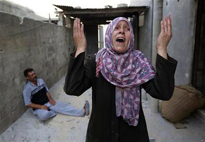 As her brother-in-law Mazen Keferna, background left, weeps, Palestinian Manal Keferna, 30, right, cries upon her return to the family house, destroyed by Israeli strikes in Beit Hanoun, northern Gaza Strip,  July 26. Photo: AP