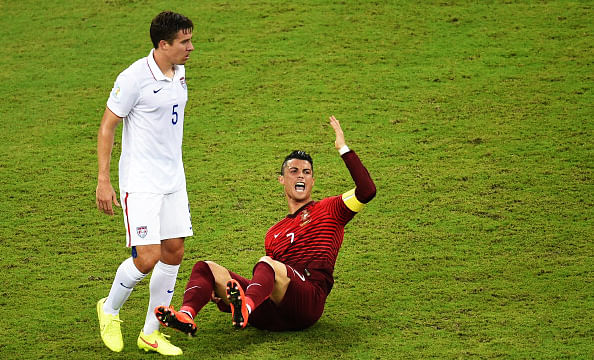 Portugal's forward Cristiano Ronaldo (down) gestures next to US defender Matt Besler (L) during a Group G football match between USA and Portugal at the Amazonia Arena in Manaus during the 2014 FIFA World Cup on June 22, 2014. Photo: Getty Images