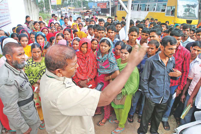 Following rumours of vacancies, a large number of garment workers throng the Sharmin Group factory at Ashulia on the outskirts of the capital yesterday asking for jobs. A security man at the gate is seen telling them to go away since there were no jobs there. Photo: Palash Khan