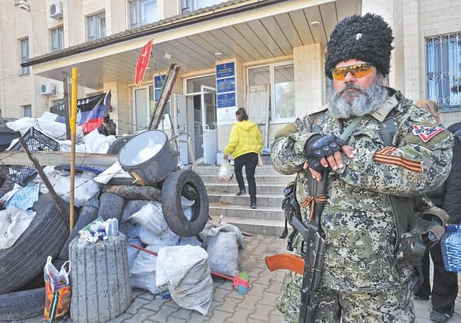 A pro-Russian militant holds a Kalashnikov as he guards a barricade outside the city hall in downtown Kramatorsk, eastern Ukraine, yesterday, a day after heavy fighting between pro-Russian militants and Ukrainian troops killed at least 34 people near the eastern Ukrainian city of Slavyansk. Photo: AFP
