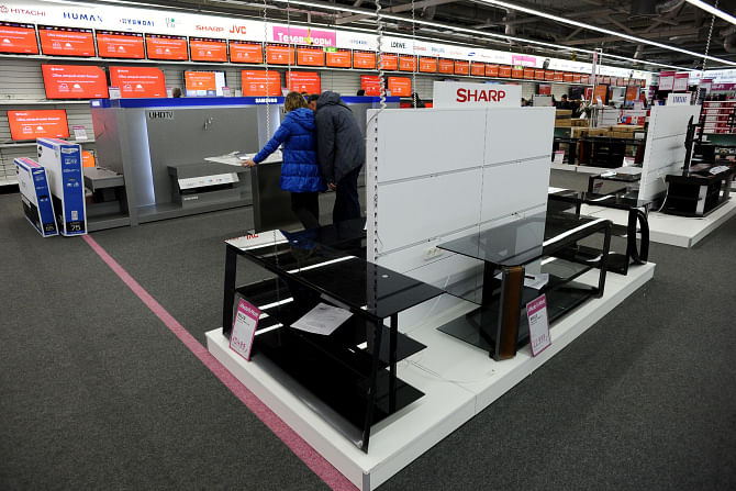 A couple looks at gadgets as they stand among the empty shelves in an electronic shop in St Petersburg, Russia on Saturday. Photo: AFP