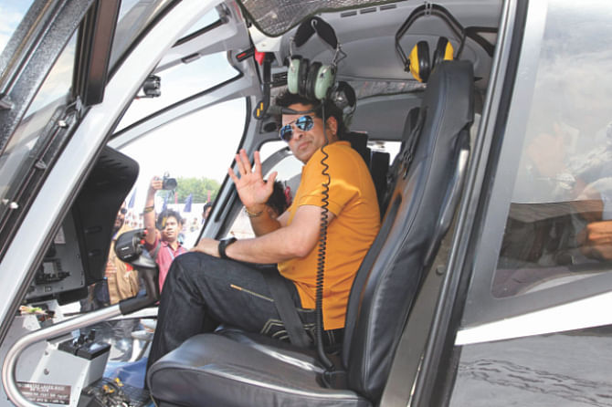 The honorary Indian Air Force group captain waves to photographers from the cockpit of a chopper. PHOTO: FIROZ AHMED