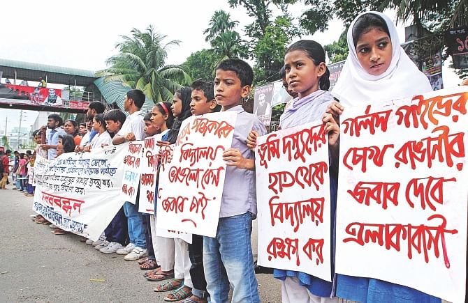 Students of Samajik Shikkhakendra Government Primary School on the capital's Bailey Road form a human chain before Jatiya Press Club yesterday protesting demolition of the school by Bangladesh Girl Guides Association during the Eid-ul-Fitr vacation. Photo: Palash Khan