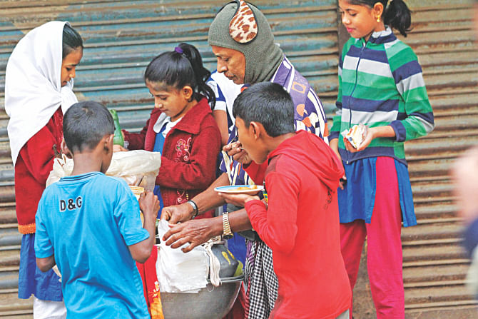 Schoolchildren having fuchka on their way back home from school at Manda in the capital. A study revealed that such food items sold in Dhaka have coliform which could cause diseases like diarrhoea, dysentery and typhoid. The photo was taken recently. Photo: Sk Enamul Haq