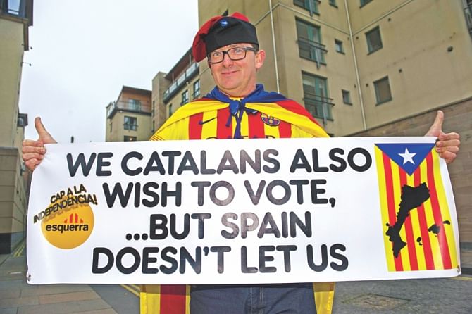 A Catalan supporter of the 'Yes' campaign holdup a banner outside the Scottish Parliament. Photo: AFP