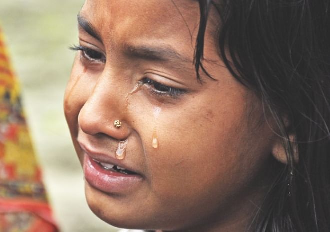 A young Indian child mourns after the death of a relative in Assam yesterday. Photo: AFP