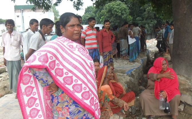 Evicted sex workers and house owners have started returning to Kandapara brothel in Tangail town and constructing makeshift structures there. Photo shows some sex workers and house owners standing on the dismantled brothel site. Photo: Star