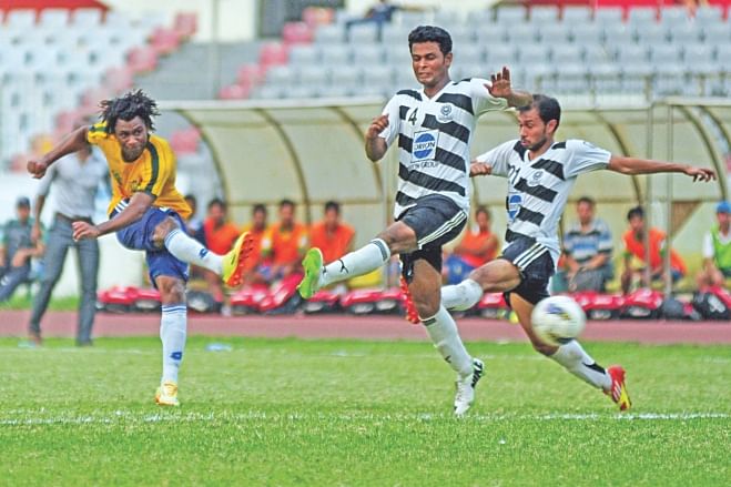 Sheikh Jamal's Haitian hitman Sony Norde rockets the ball past Mohammedan defenders to score the first goal against the black and whites in their Bangladesh Premier League match at the Bangabandhu National Stadium yesterday. PHOTO: STAR