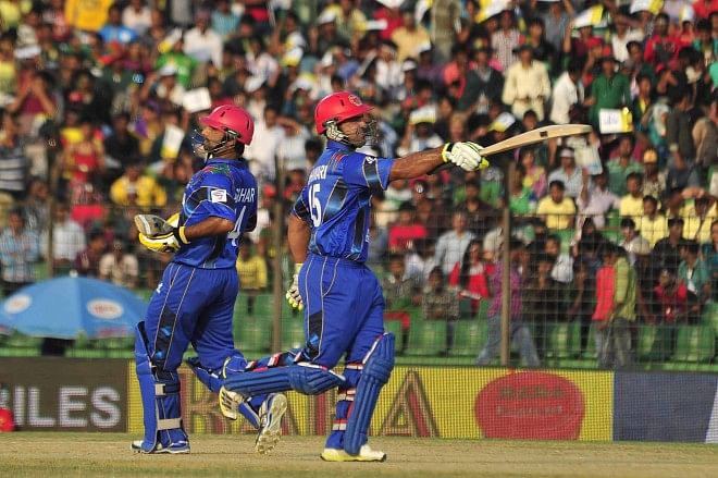 PARTNERS IN HISTORY: Afghanistan's Samiullah Shenwari (R) salutes the crowd on reaching his half-century while he and Asghar Stanikzai, who also hit a half-century, run a single to lift their side against Bangladesh in the Asia Cup at the Fatullah Cricket Stadium in Narayanganj yesterday. PHOTO: STAR