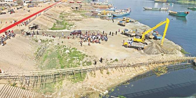 In this Star file photo, a digger at Kanchpur bridge on the Shitalakkhya river is seen evicting sand traders who occupied the river way beyond the walkway, marked in red, built on the bank.