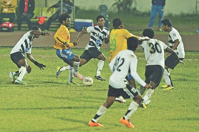 Sheikh Jamal DC's Haitian forward Sony Norde (2nd from L) is surrounded by five Mohammedan players as he tries to advance during their Bangladesh Premier League match at the Bangabandhu National Stadium yesterday.  PHOTOS: STAR